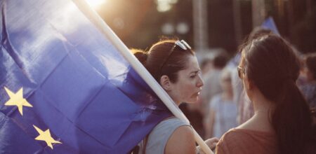 Due donne con la bandiera dell'Unione europea durante una manifestazione