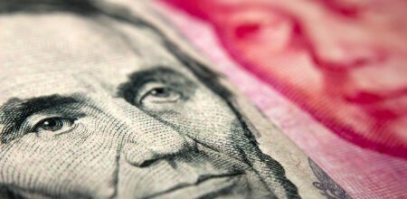 Close-up of an American banknote (showing Lincoln) and a Chinese yuan banknote (Mao Zedong). (iStock/claffra)