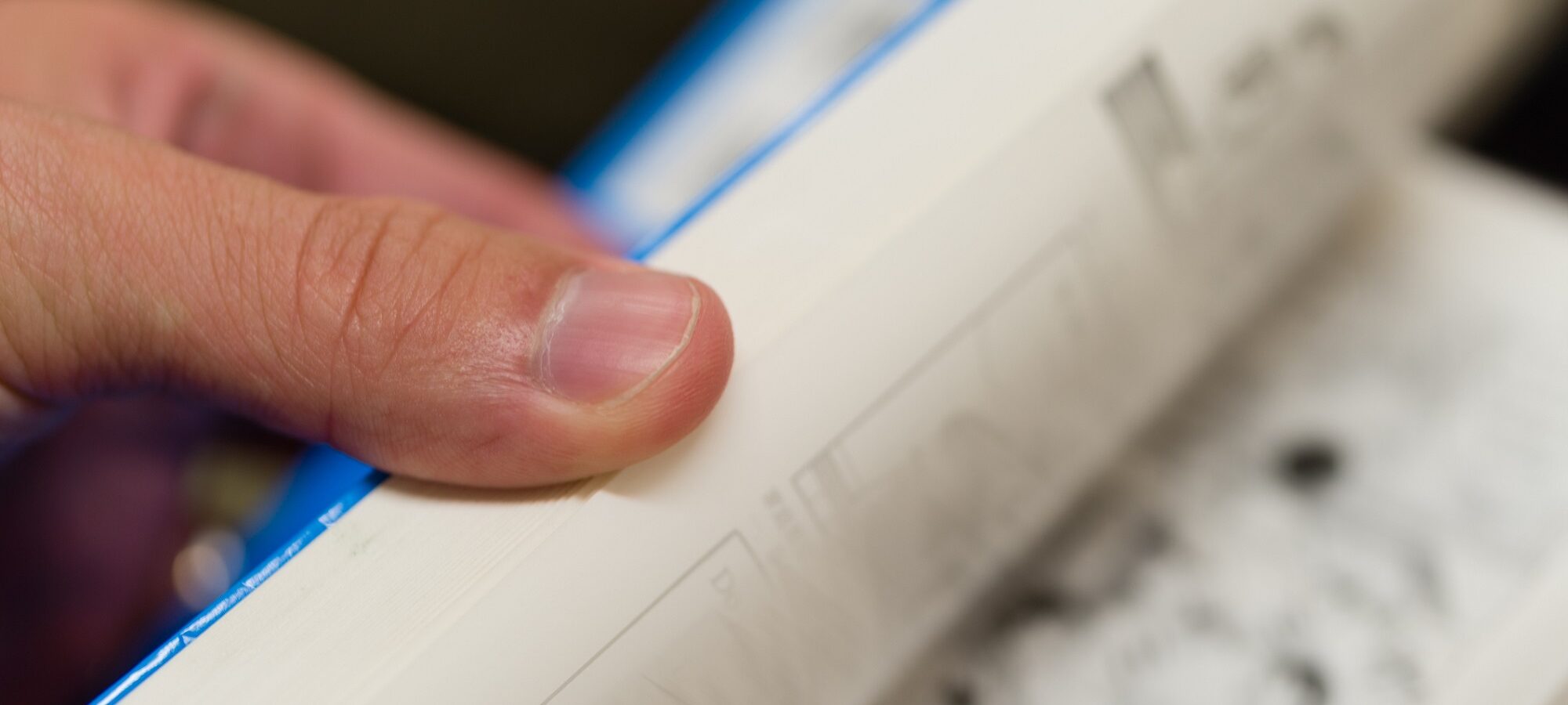 Flipping through the pages of a paperback book. (iStock/justtscott)