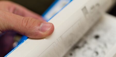 Flipping through the pages of a paperback book. (iStock/justtscott)