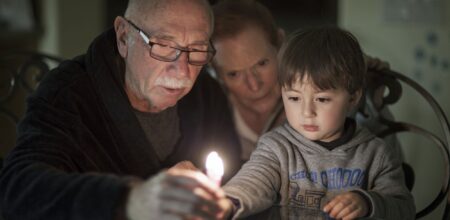 Jewish Family lighting Hanukkah Candles (iStock/Enzo Nguyen@Tercer Ojo Photography)