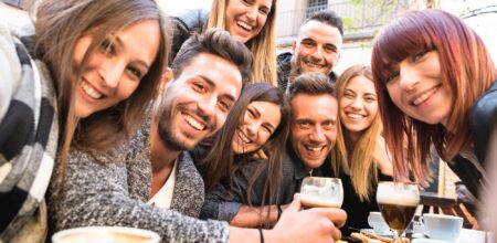 Friends taking selfie at bar restaurant drinking cappuccino (iStock/ViewApart)