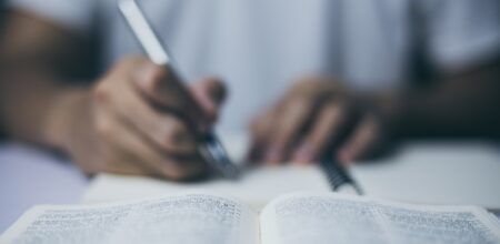 Man is taking notes with holy bible. (iStock/ChristianChan)