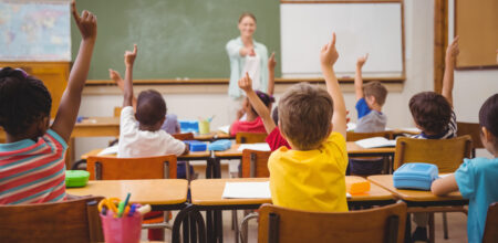 Students raising their hands during class