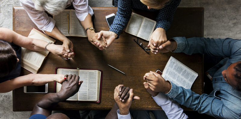 Group of people holding hands praying worship believe