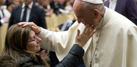 Papa Francesco benedice una donna.