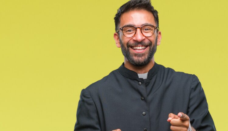 Adult hispanic catholic priest man with happy and funny face.