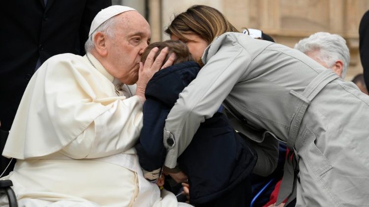 papa Francesco benedice un bimbo (Vatican Media).