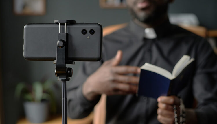 Un sacerdote mentre fa una diretta video con i feceli.